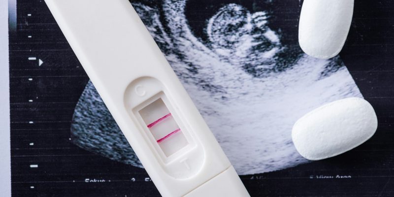 close up of pills and pregnancy test on ultrasound image