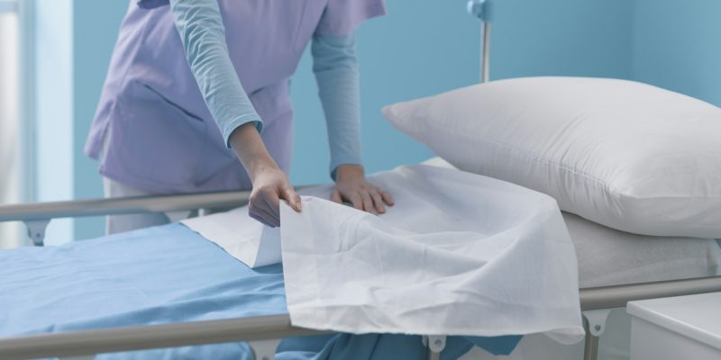 Expert young nurse making the bed at the hospital