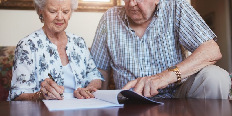 Senior husband and wife doing paperwork together at home