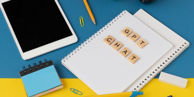 Work and study with the help of a chat bot. Words in wooden letters. Work table with open notebook.